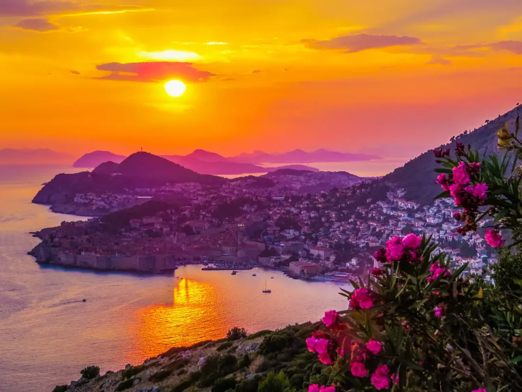 Vue panoramique sur Dubrovnik et ses remparts au coucher du soleil, avec la mer Adriatique et les îles à l'horizon
