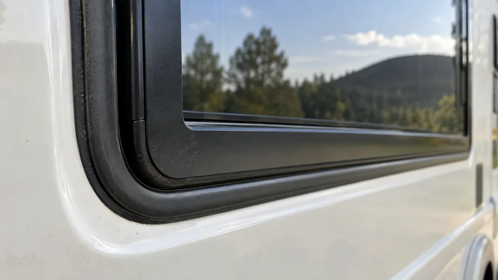 Humidité et infiltrations dans un camping-car : gros plan sur le joint d’étanchéité d’une fenêtre latérale.