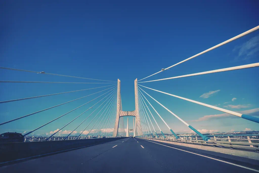 Route traversant un grand pont à haubans sous un ciel bleu au Portugal